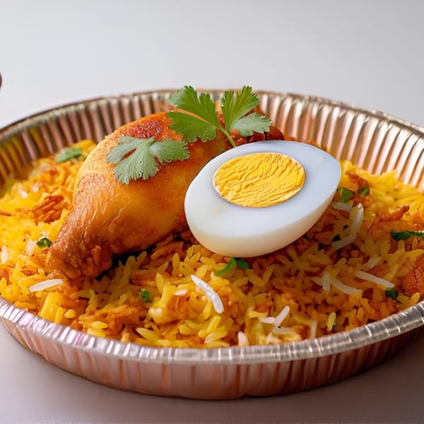 Chicken biryani with a hard-boiled egg and cilantro in a foil container from Namaste India Cafe.